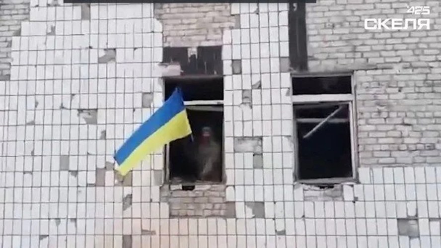 Український військовий біля будівлі з прапором України у центрі Костянтинівки