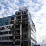 Пошкоджений фасад бізнес-центру «Інком» у Солом'янському районі Києва після удару БпЛА, вибиті вікна та горівші автівки на